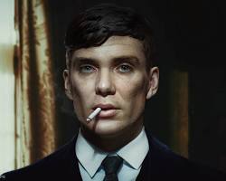 Retrato em close de Thomas Shelby, da série Peaky Blinders, 
                            com seu característico corte de cabelo curto, olhar fixo, terno escuro e um cigarro na boca.